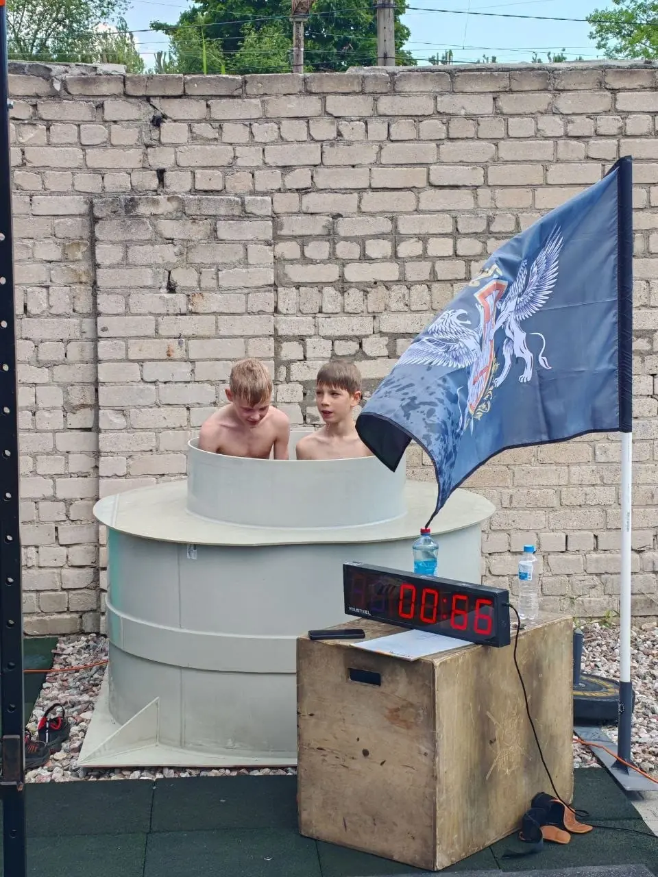 Дети в ледяной купели у флага клуба